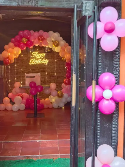 The entrance view of a party, giving a glimpse of the warm and inviting ring decoration inside, done in shades of pink, peach, and gold.