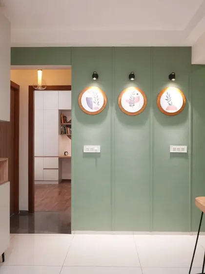 A different take on a statement wall, using a solid sage green color and minimalist circular art to create a serene and sophisticated look.