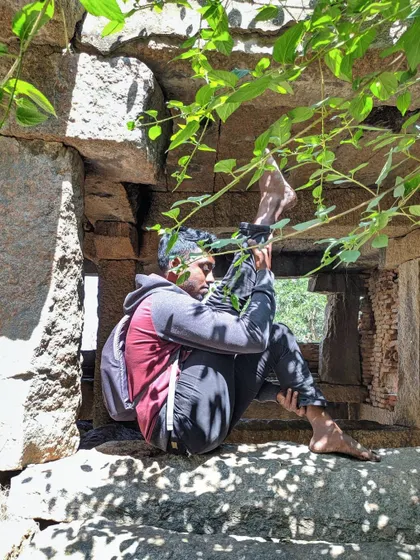 A deep hip-opening stretch, Akarna Dhanurasana (Archer Pose), while sitting in the window of an old stone structure. I let my body talk and explore its own range of motion.