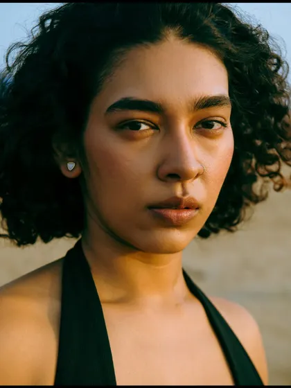 A tight, intimate close-up where the focus is entirely on the model's expressive face and the beautiful evening light.