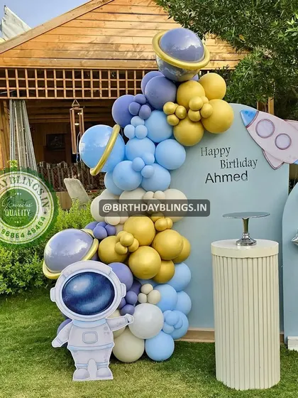 A close-up of the astronaut cutout and the balloon garland, with planets integrated into the arrangement.