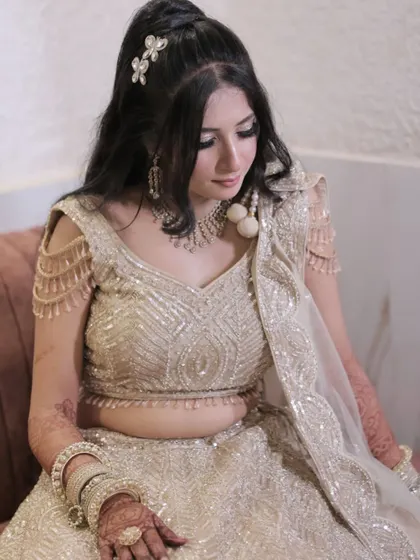 An elegant pose from the engagement night. The golden lehenga is paired with smokey eyes and a half-ponytail hairstyle for a chic and modern look.