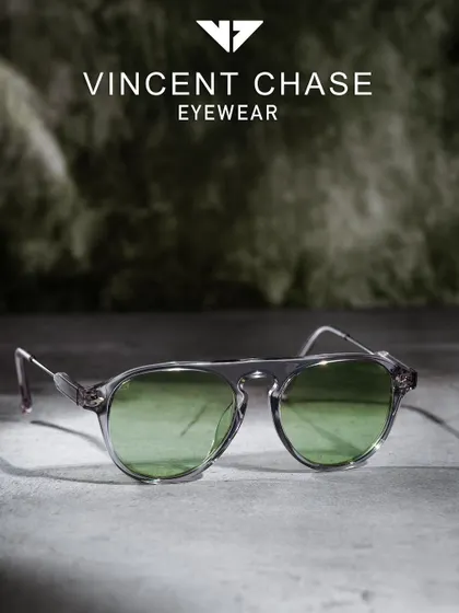 A moody, atmospheric shot of Vincent Chase eyewear. The textured surface and soft background lighting create a sophisticated look for this Lenskart collection piece.