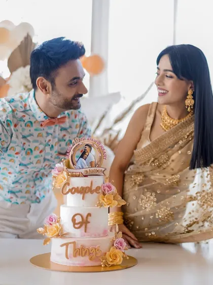 Amrita Rao and RJ Anmol with their custom anniversary cake, which features a topper of their YouTube channel logo, "Couple of Things."