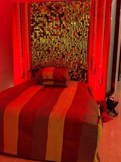 Setting the mood for a Sufi night at home. We used a gold sequin backdrop and dramatic red lighting to create a rich and ambient seating area.