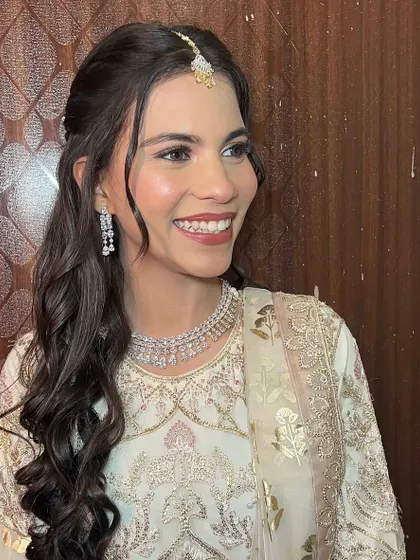Shining bright in a beautiful white and gold outfit, her makeup features a dewy base and defined eyes.