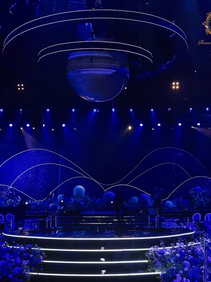 The stage was the heart of our galaxy. I designed a multi-layered backdrop depicting cosmic waves and a starry night, with a large planet suspended above the central platform, creating a truly stellar focal point.