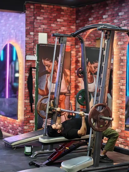 A client uses the Smith machine for a bench press. This machine provides extra stability, making it a great tool for safely pushing heavy weight without a spotter.