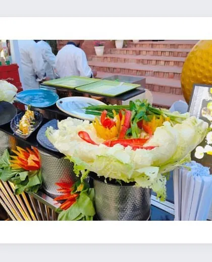 A fresh salad and appetizer station, beautifully decorated with carved vegetables and flowers. We believe in making every corner of our setup visually appealing.