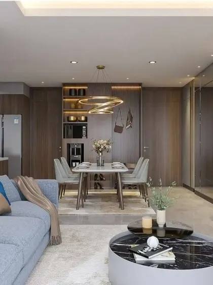 An open-plan living space with a blue sofa, dark wood accents, and a dining area integrated into the main living zone.