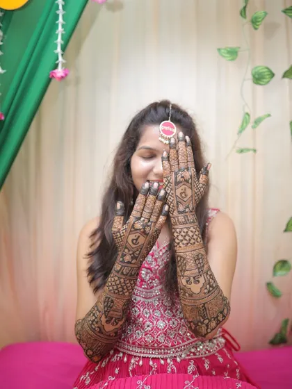 The bride showing off her full back-hand mehendi. The design is intricate and personalized, a perfect reflection of her style.