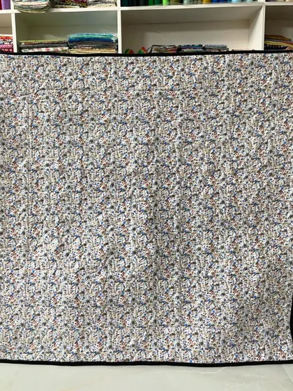 The back of the assorted baby quilt, featuring a simple, uniform pattern that is soft to the touch.