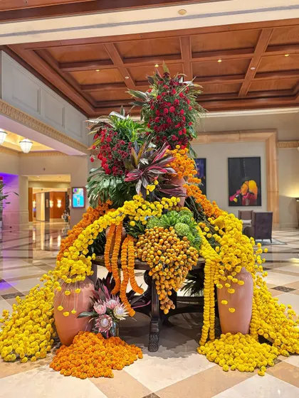The combination of yellow and orange marigolds with the deeper tones of red flowers and green leaves creates a balanced and visually rich composition.