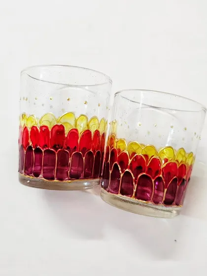 A pair of tea light candle cups painted with a 'Curvy Rose' design. The warm red, pink, and yellow tones create a fiery effect, perfect for adding a pop of color to your decor.