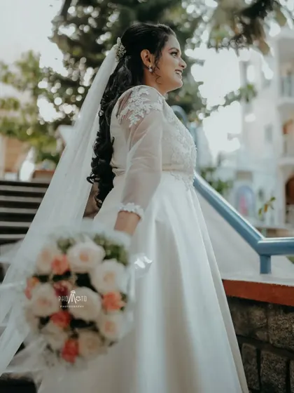 A beautiful profile shot of the bride in her elegant white dress, holding her bouquet.