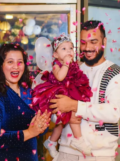A magical moment as flower petals rain down on the birthday girl and her parents. This is a perfect shot to capture the excitement of the celebration.