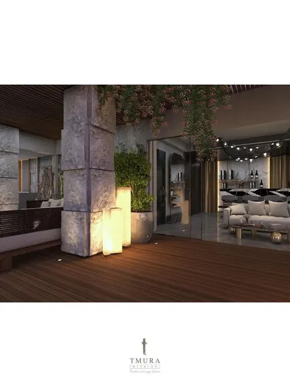 The wooden deck and soft lighting from the floor lamps create a warm and inviting atmosphere on this terrace, with a view into the elegantly designed interior lounge.