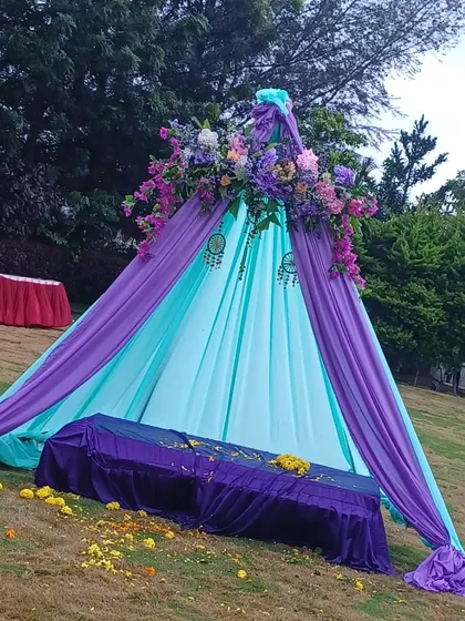 A teepee-style seating arrangement for a Mehendi, using purple and turquoise drapes for a bohemian vibe.