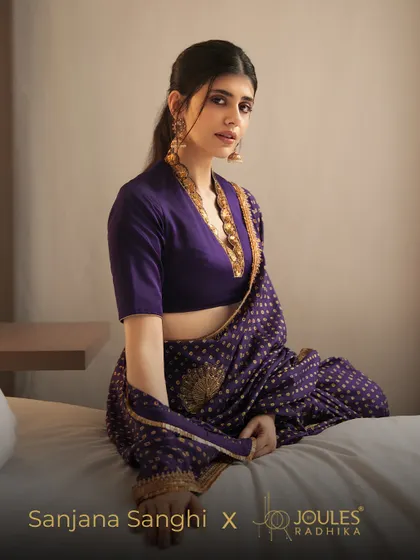 A full shot of Sanjana Sanghi, showing how the statement earrings and necklace-lined blouse create a cohesive and stylish ensemble.