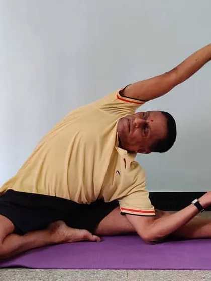 Another stage of Parivrtta Janu Shirshasana with a belt, showing how to work towards the final expression of the pose.