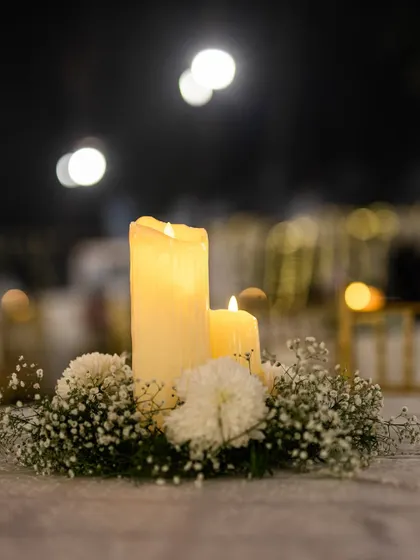 A simple yet elegant centerpiece of candles and baby's breath. Thoughtful details like this on every table contribute to the overall ambiance of the event.