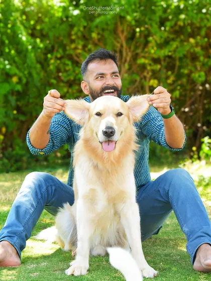 Dads and their dogs have a special kind of bond. This playful "dumbo ears" shot perfectly captures the fun and silly relationship between this man and his fluffy companion.