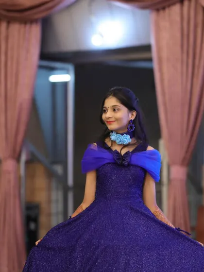 A beautiful profile shot of our client in her blue gown, showing the elegant off-shoulder design.