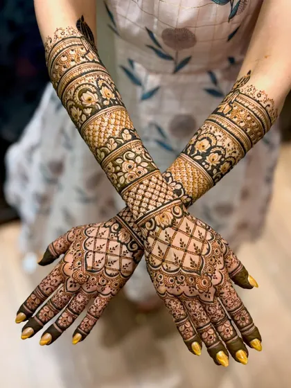 A crossed-hands view of the intricate bridal design.