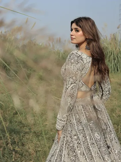 An artistic shot capturing the intricate embroidery and the open-back design of the black and white lehenga blouse.