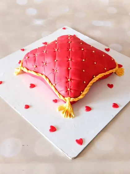 A closer look at the quilted fondant pillow cake, showing the detailed texture and gold accents. This design is perfect for a ring ceremony or engagement party.