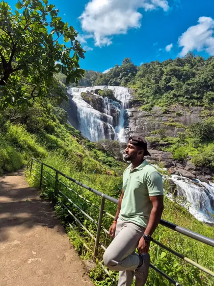 Leaning against the railing, taking in the full glory of Mallalli Falls. The scale of the waterfall is truly impressive.