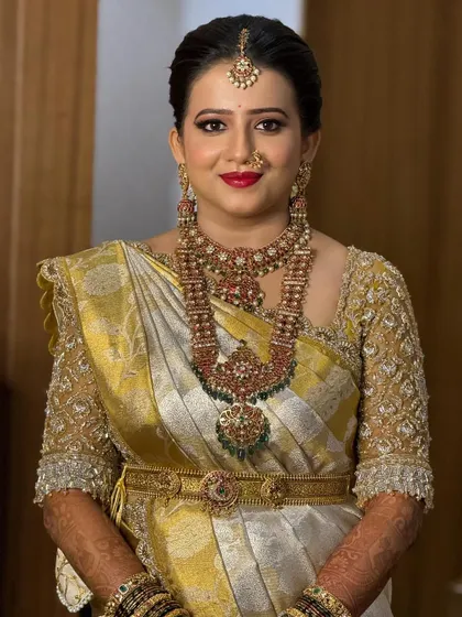 A radiant smile from the bride. Her custom gold embroidered blouse and traditional jewelry complete her stunning South Indian bridal look.