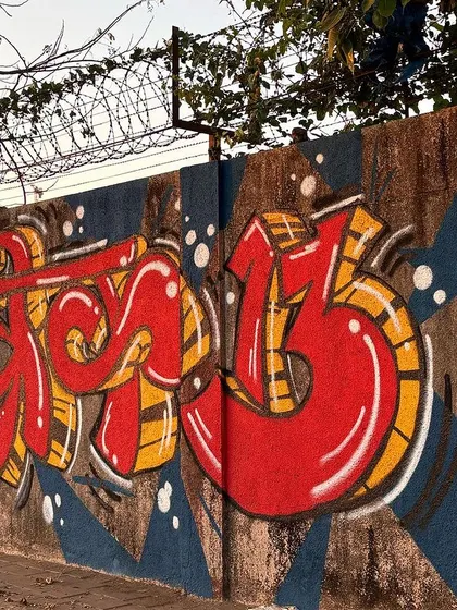 A wider shot of the Devanagari graffiti against its blue background, showing how it transforms the dull concrete wall.