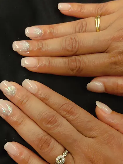 This is a lovely example of a 'your nails but better' look. A sheer nude polish is enhanced with a very subtle touch of silver sparkle on the accent nails.