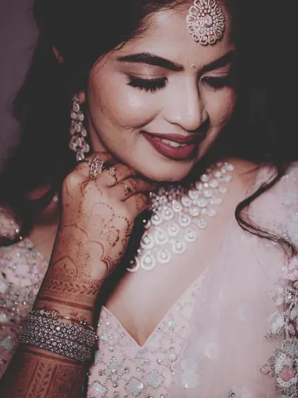 A beautiful close-up of the bride, admiring her stunning diamond necklace. We pay close attention to capturing the details of your bridal look.
