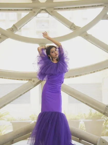 A powerful pose in the purple gown. This dress is all about confidence and style.