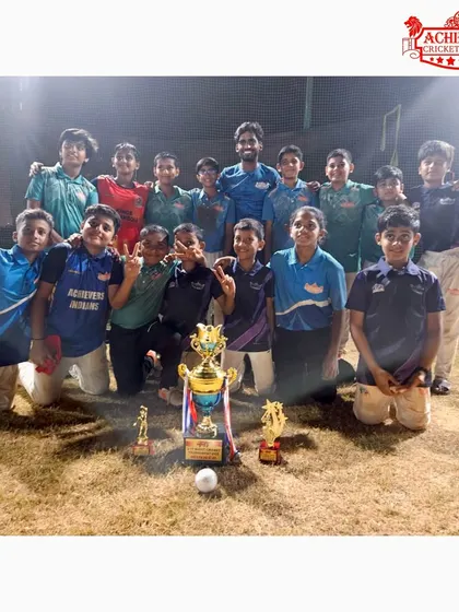 The complete U-11 championship squad with their trophies, celebrating a fantastic win under the floodlights.
