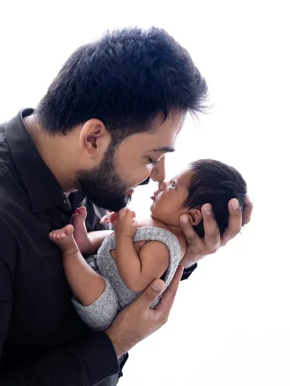 The color version of the father and newborn portrait. The natural skin tones and soft lighting create a warm and lifelike image that is just as powerful as the black and white version.