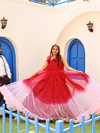 A fun and breezy pre-wedding photo. The client is wearing a red and pink ombre gown that she can twirl for beautiful, dynamic shots.