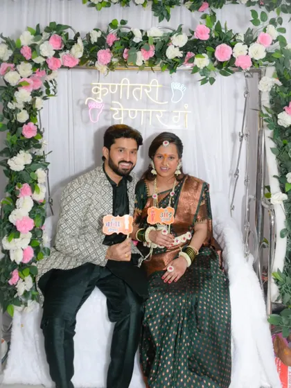 Another great shot of the couple with their fun props, smiling for the camera in front of their beautiful floral and neon backdrop.