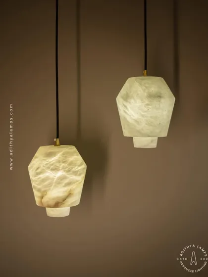 These geometric pendants are carved from a single piece of beige marble. Their unique, faceted shape and the soft glow from within make them a subtle yet elegant choice for modern kitchens or bedside lighting.