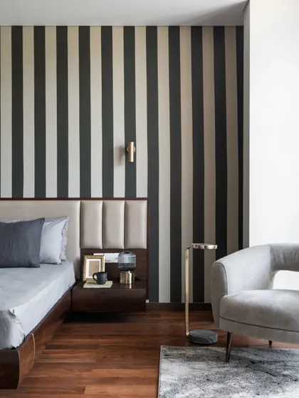 A closer look at the bedroom reveals how we layer textures and materials. The combination of a leather-paneled headboard, a bold wallpaper, and a sleek side table creates a composition that is both visually rich and functionally sound, perfect for a restful escape.