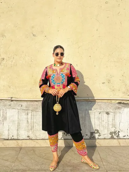 Styling this vibrant ethnic suit with sunglasses for a modern, cool-girl twist.