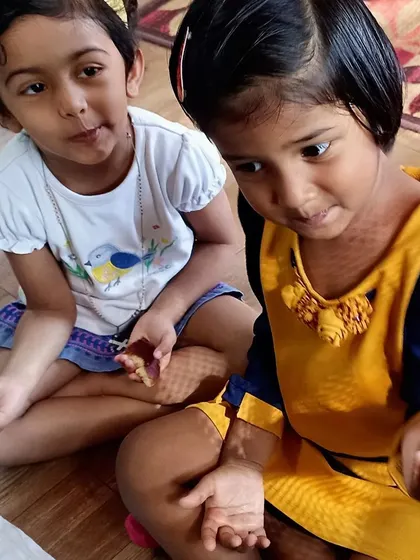 Children proudly show the energy balls they have just rolled. This activity is fantastic for sensory exploration and strengthening their hand muscles.