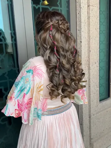 Loosely curled hair laced with pink threads for a festive sparkle. This creative hairstyle was the perfect finishing touch for a fun carnival-themed event.
