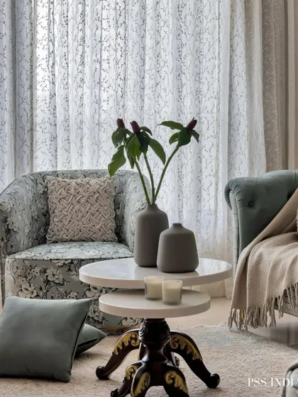 This living area is styled for comfort and elegance. The floral-patterned seating, layered throws, and soft lighting create a cozy atmosphere perfect for relaxing or hosting guests.