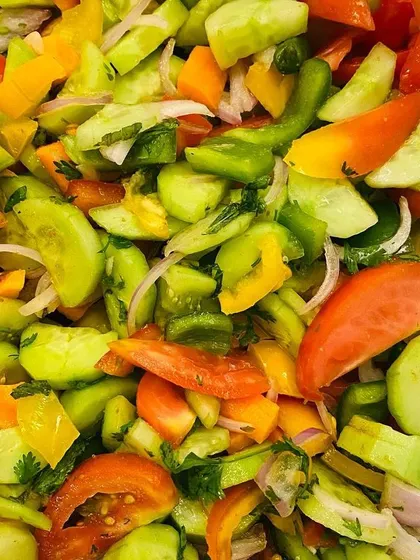 A close-up of the fresh, colorful vegetables I use, like cucumbers, tomatoes, and bell peppers, all chopped and ready.