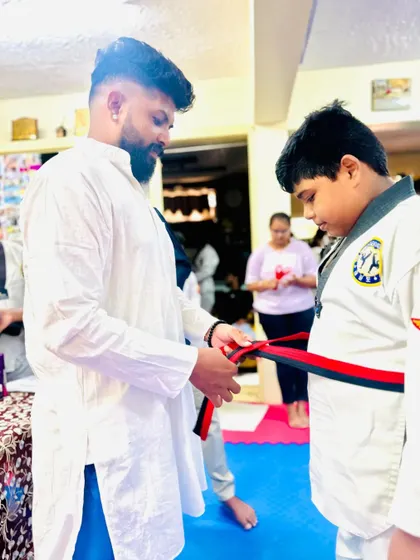 A student receives his new belt with pride.