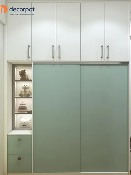 A beautiful sliding wardrobe in a soft mint green, featuring an integrated open display unit with lighting. It's a perfect storage solution for a child's room, blending style and practicality.