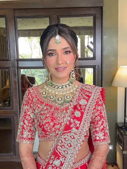 The front view of the bride, her hair neatly tied in a classic bun, allowing her beautiful smile and bridal jewelry to be the main focus.